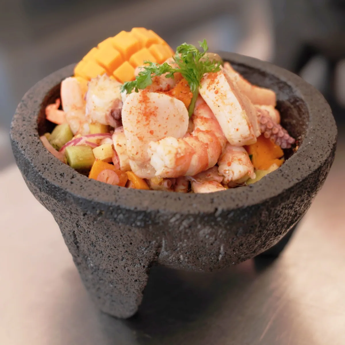 Molcajete Playa David con camarón, pulpo y callo de hacha sobre mango